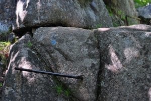 An iron rung hammered into the rock face of a steep slope.